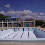 Bassin de piscine extérieure entièrement vidé, au revêtement blanc et aux lignes bleues