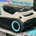 Robot nettoyeur de piscine électrique blanc et noir à chenilles, exposé en magasin