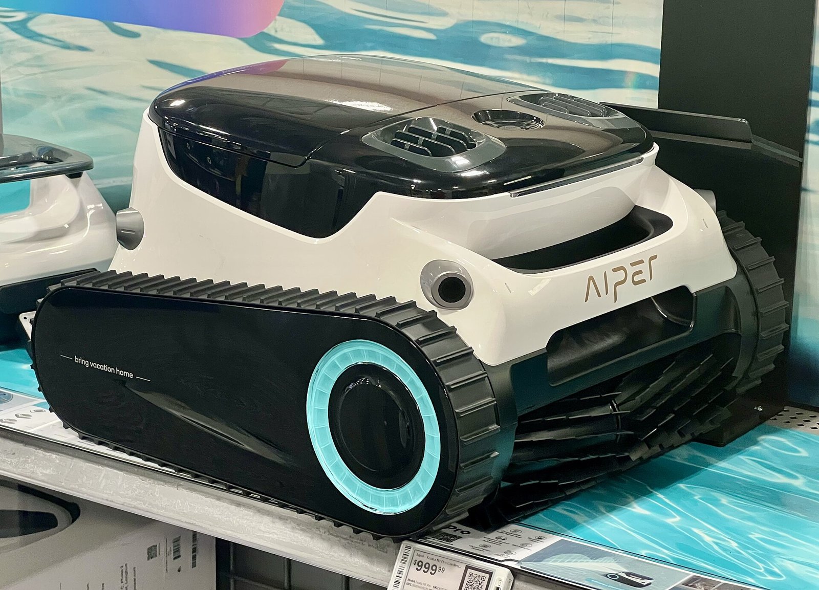 Robot nettoyeur de piscine électrique blanc et noir à chenilles, exposé en magasin