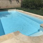 Piscine privée enterrée dans un jardin, avec volet roulant