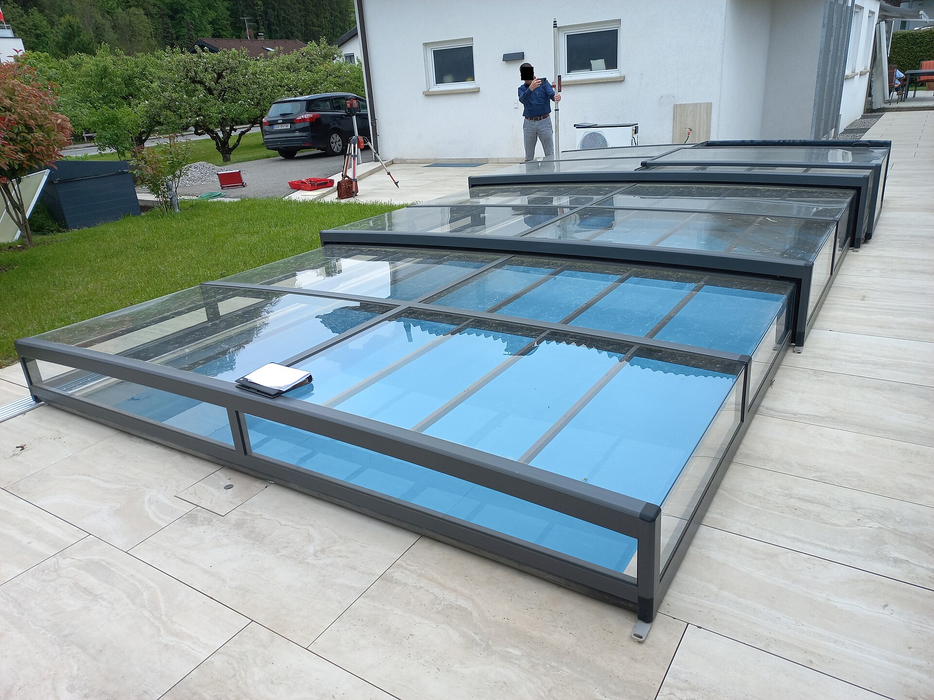 Abri de piscine télescopique recouvrant un bassin dans un jardin