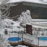 Deux spas extérieurs entourés de neige devant un chalet en hiver