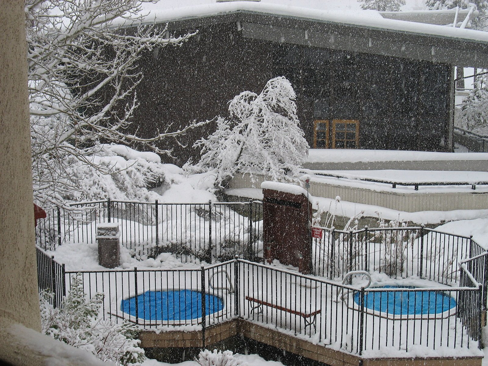 Deux spas extérieurs entourés de neige devant un chalet en hiver